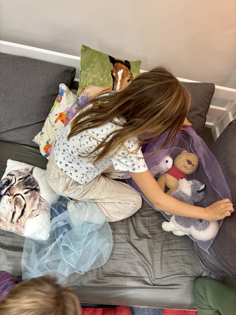 Kuscheltierübernachtungsparty Nora deckt ihre Lieblinge zu