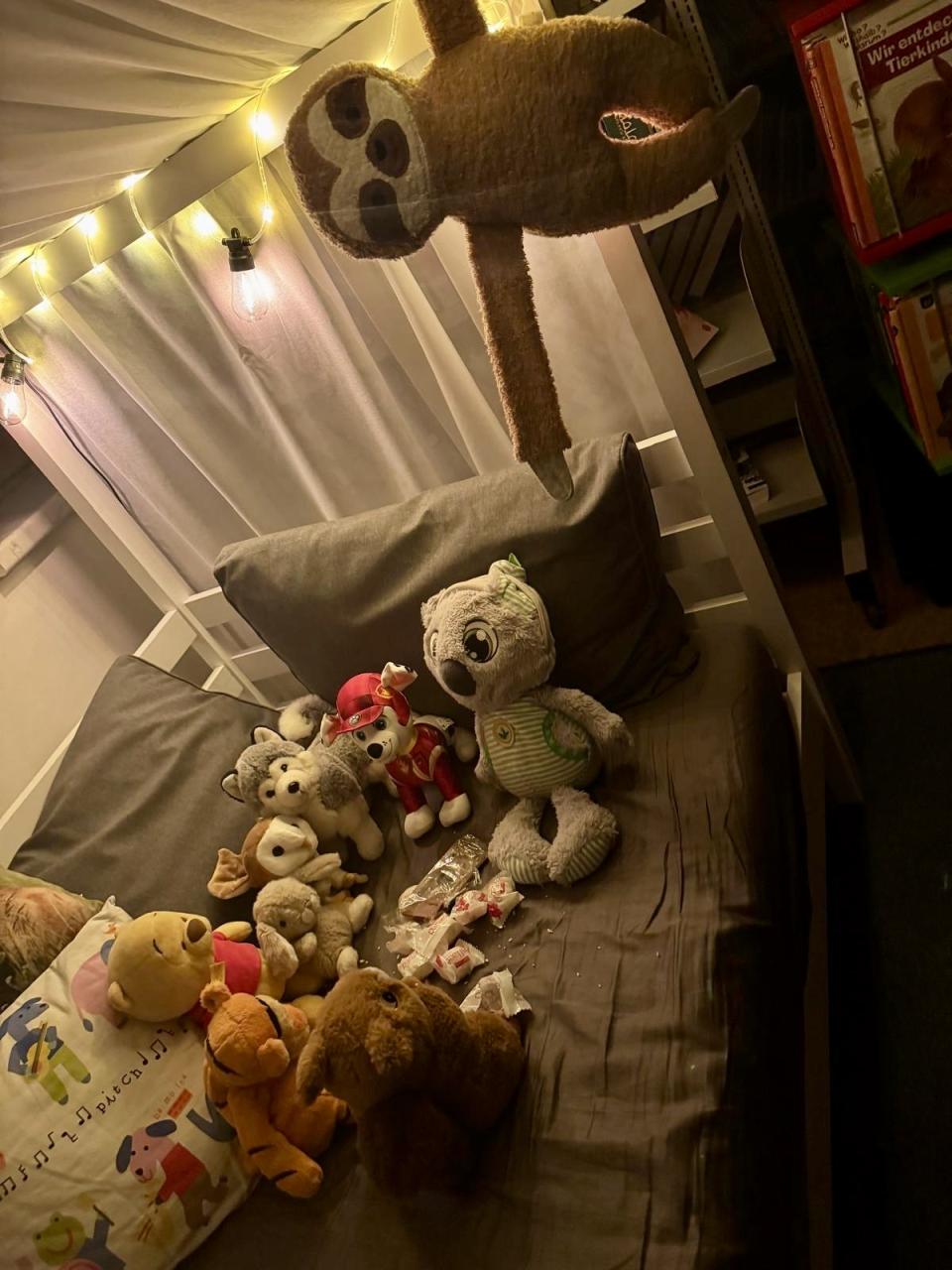 Kuscheltierübernachtungsparty alle Tiere im Bett beim Naschen