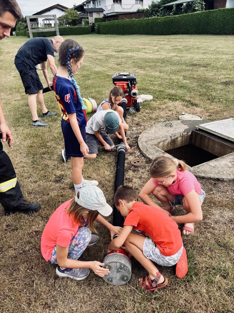 CS Feuerwehr Kinder vorm Schacht schließen Schlauch an 22 07 2026