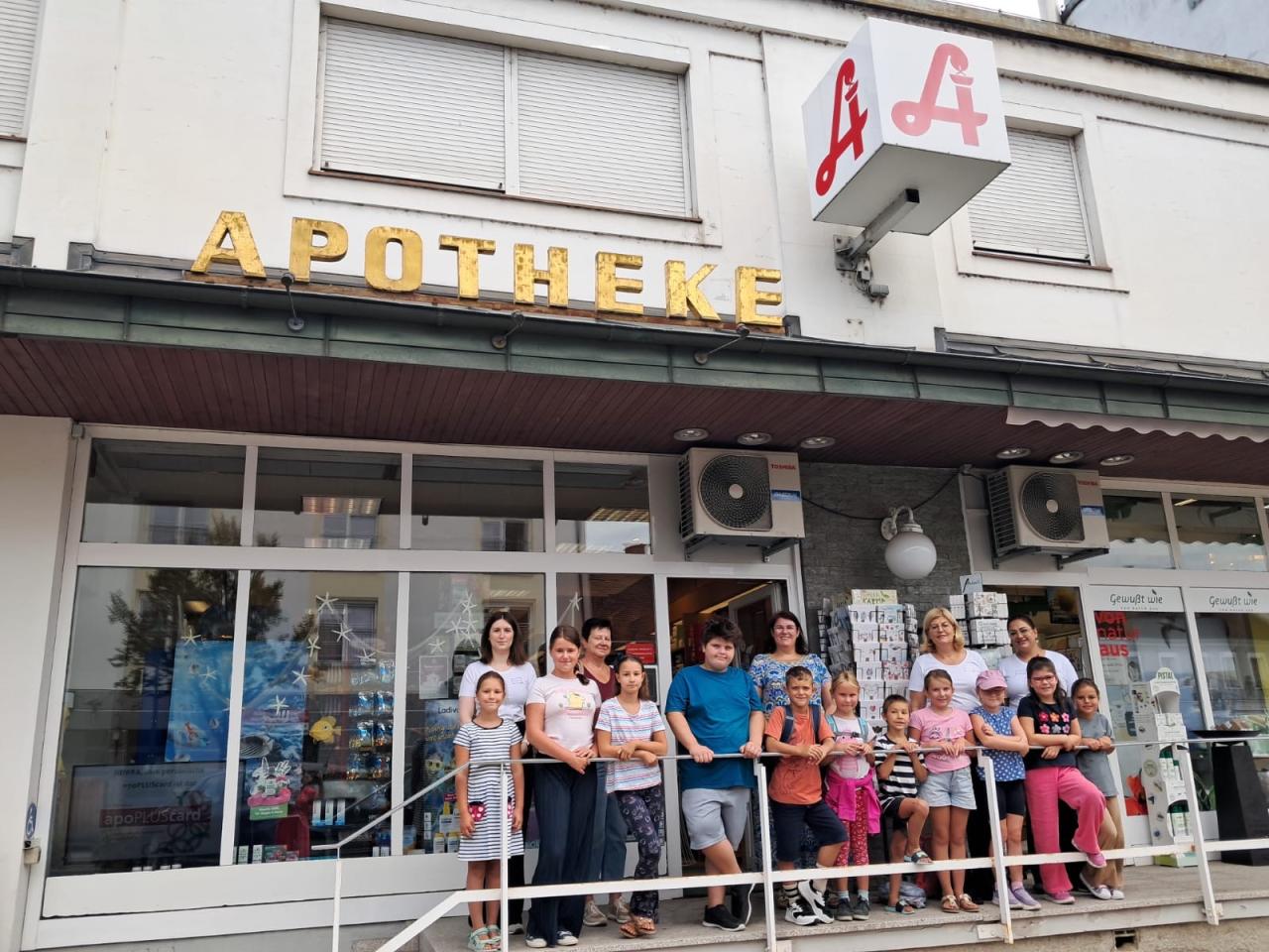CS 19 08 2026 Gruppenfoto fern vor der Apotheke