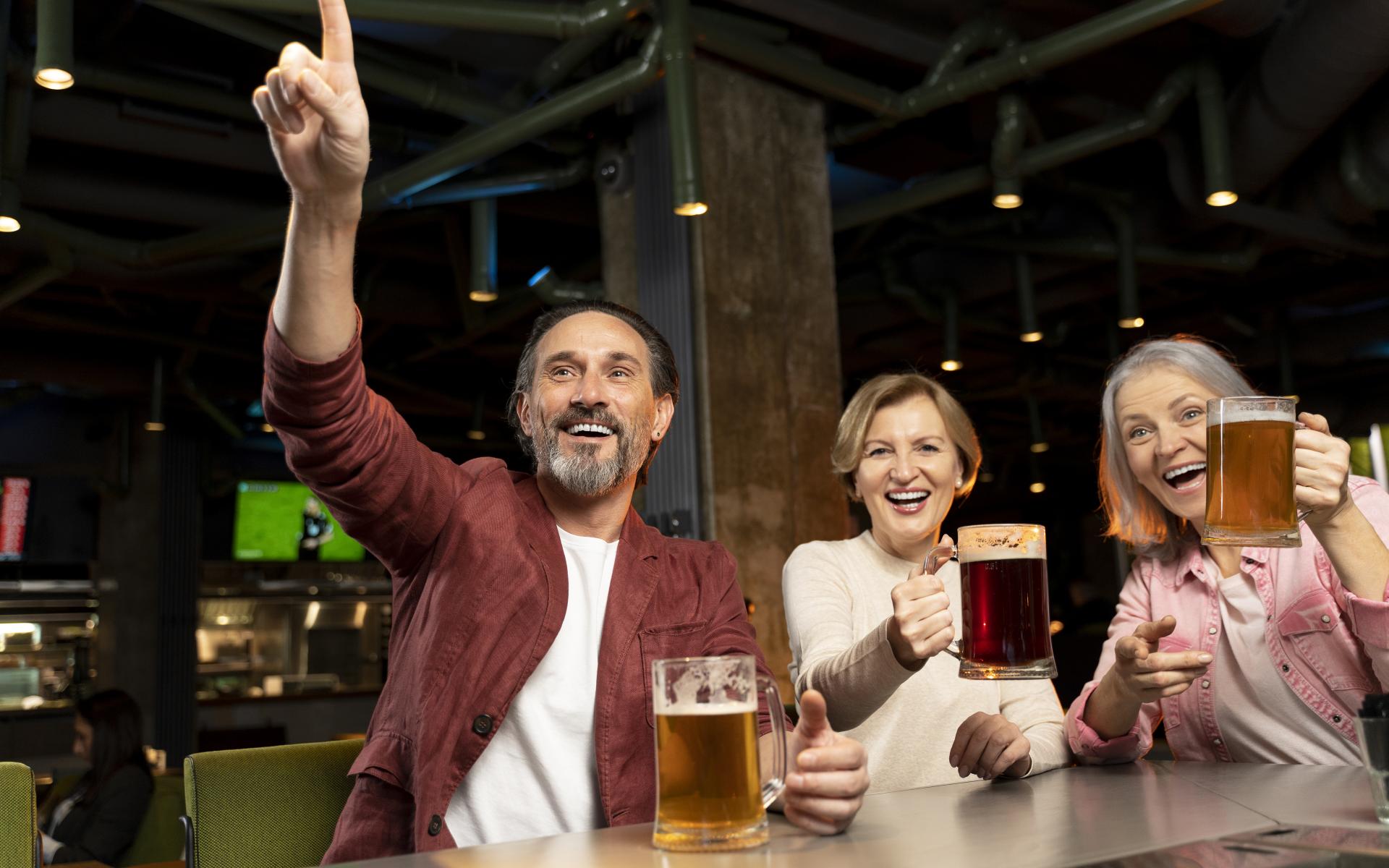 Drei Personen mit Bier lachend